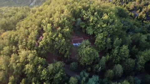 Isolated traditional Orthodox mountain chapel in a pine forest at sunset. Stock Footage 326352953