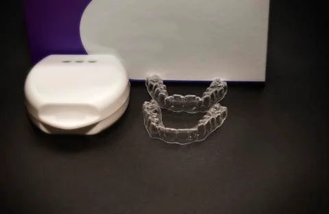 Isolated transparent teeth prosthesis with its box over black for design Stock-Fotos