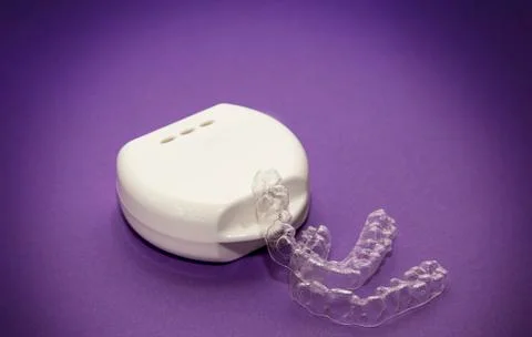 Isolated transparent teeth prosthesis with its box over purple for design Stock-Fotos