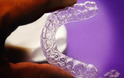 Isolated transparent teeth prosthesis with its box over purple for design Photos