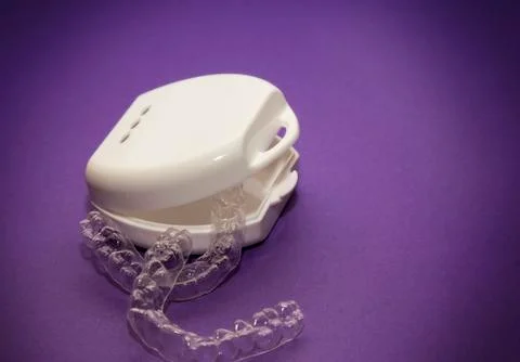 Isolated transparent teeth prosthesis with its box over purple for design Stock-Fotos