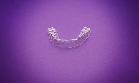 Isolated transparent teeth prosthesis over purple for design Foto stock