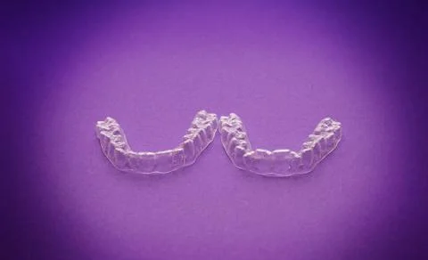 Isolated transparent teeth prosthesis over purple for design Foto stock