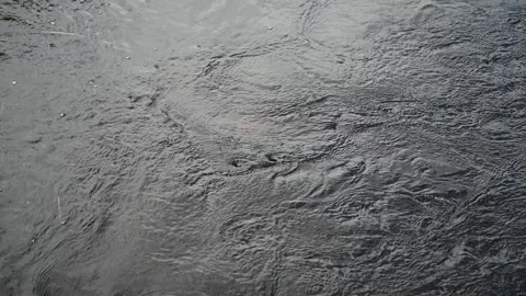 Isolated view of fast moving dark gray water reflecting a cloudy sky creating an Stock Footage 337847321