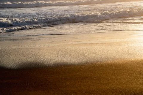 Isolated view of the waves on the shore at sunset. Stock Photos