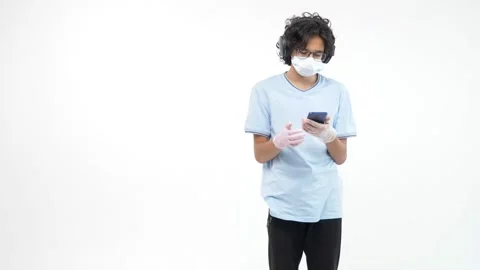 Isolated white background. in gloves and a mask with a phone is dancing Vidéo 135102877
