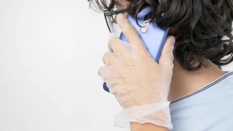 Isolated white background. guy in gloves, a medical mask is talking on the phone Stock Footage 135853745