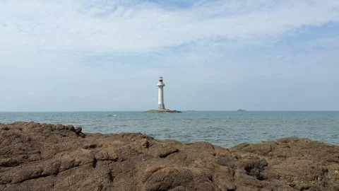 Isolated White Lighthouse on Small Rock Island in the Blue Sea Stock-Footage 330842440