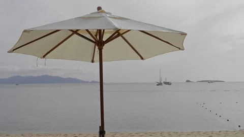 Isolated white sun parasol on tropical beach, exotic sea view background. Stock Footage 106916704