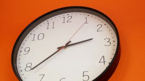 Isolated white wall clock with black numbers on orange background Stock Footage 148388056