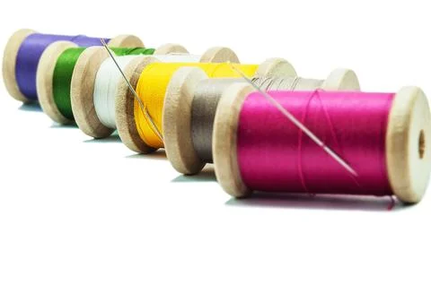 Isolated wooden spools of thread with a needle Stock Photos