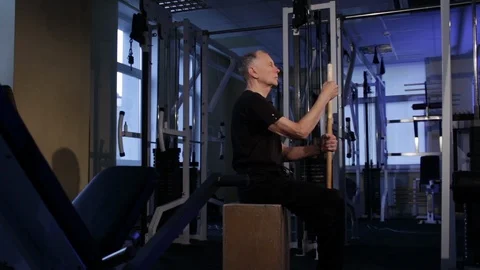 Isometric exercise with a stick.an elderly man holds a stick vertically in front Video stock 115246398