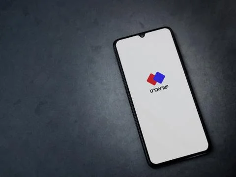 Isracard app launch screen with logo in hebrew text on the display of a black Stock Photos