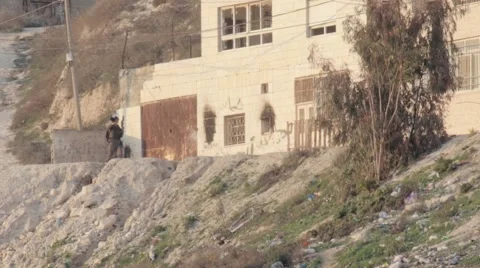 Israeli Soldier walking in Arab neighborhood with tear gas rifle Stock Footage