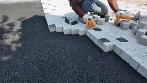 ISTANBUL, TURKEY - AUGUST 11, 2026: Construction worker laying paving stones Stock Footage 341932829