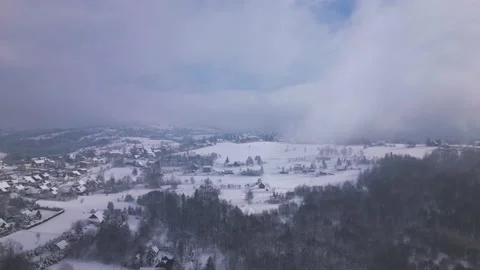 Istebna, PL - Snow - Push Shot over valley through cloud towards wooden building 動画素材 231863836