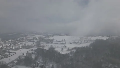 Istebna, PL - Snow - Push Shot over valley through cloud towards wooden building 動画素材 231864386