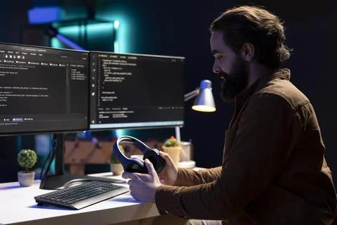 IT admin listening music, testing and debugging code for software applications Stock Photos