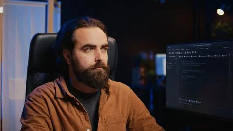 IT admin thinking and drinking coffee while working on PC early in the morning Foto stock