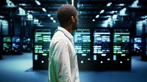 IT admin walking in server farm Stock Footage 246240624