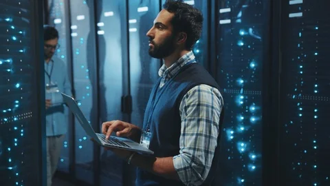 IT administrator inspecting data cabinets in digital server room. Bearded Stock Footage 119278631