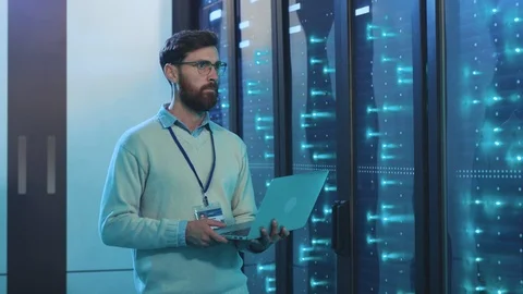 IT administrator with laptop opening server rack cabinet monitoring system Stock Footage 119233196