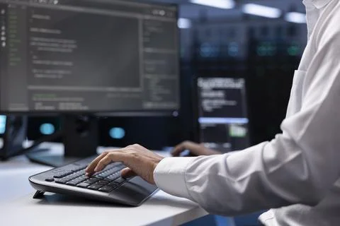 IT administrator working on PC in hardware room housing server rackmounts 스톡 사진