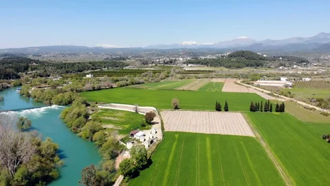 It is aerial view over the small river which is on the green meadow. Stock Footage 105411976