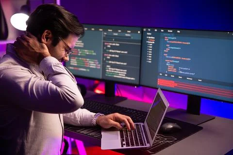 IT being tried of overwork on solve problem at neon light office. Surmise. Stock Photos