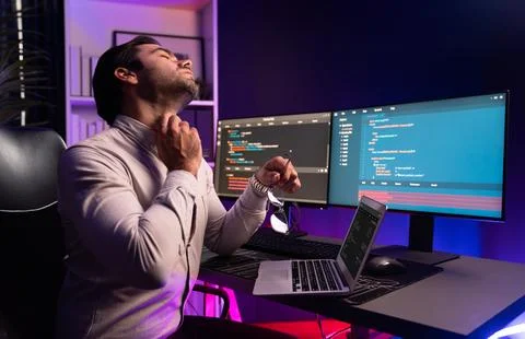 IT being tried of overwork on solve problem at neon light office. Surmise. 库存照片