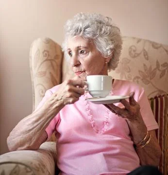 It can get a bit lone around here...a senior woman having a cup of coffee at Stock Photos