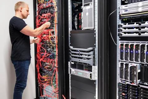 IT Consultant Working With Network Cables Connected To Servers Stock Photos