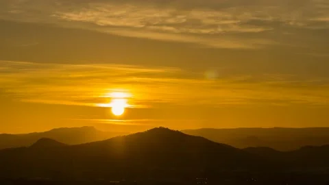 It dawns behind the clouds and mountains of a small town Stock Footage 148500450