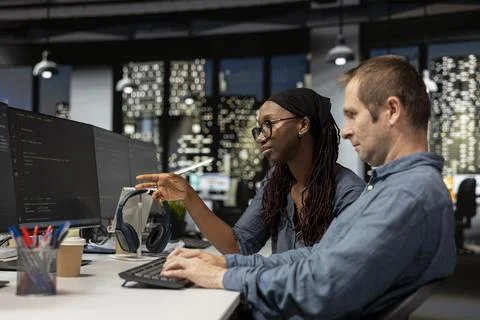 IT department staff members coding on PC in startup office 库存照片