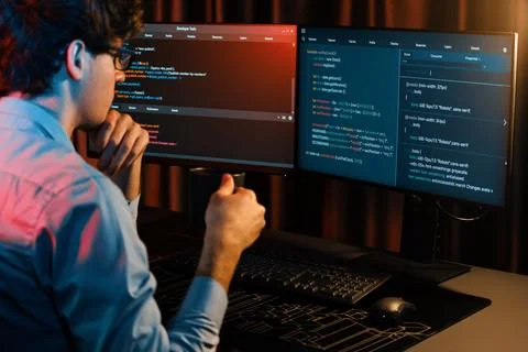 IT developer concentrating software while drinking coffee at neon light. Gusher. Stock Photos