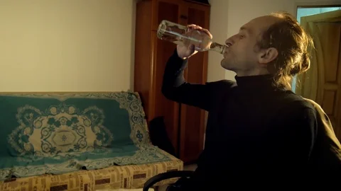 IT developer drinks vodka and watches monitor screen at his small apartment Stock Footage 105465943