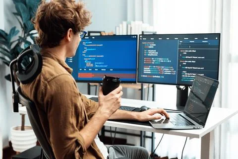 IT developer holding coffee cup with looking online software on pc. Gusher. Foto stock