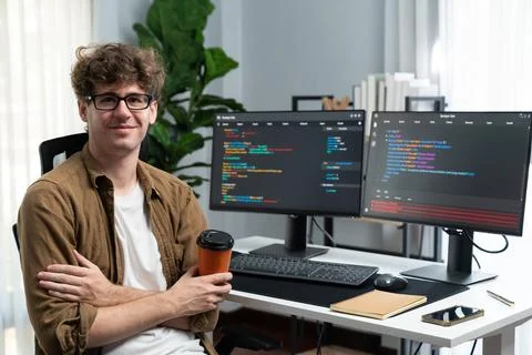 IT developer looking at camera and holding coffee cup. Gusher. Stock Photos
