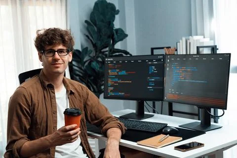 IT developer looking at camera and holding coffee cup. Gusher. Stock Photos