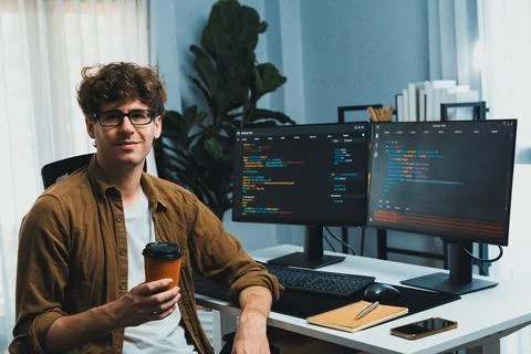 IT developer looking at camera and holding coffee cup. Gusher. Stock Photos