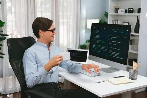 IT developer looking camera, holding coffee cup with coding on pc. Pecuniary. Foto stock