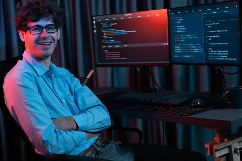 IT developer looking at camera with software development information. Gusher. Foto stock