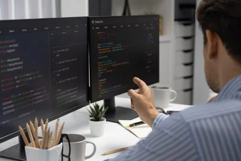 IT developer man pointing information center on laptop at back side. Postulate. Stock Photos