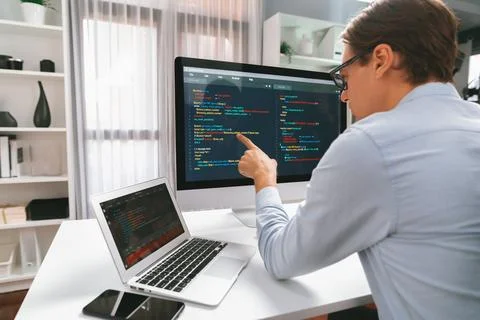 IT developer pointing on coding software on pc comparing laptop. Pecuniary. 스톡 사진