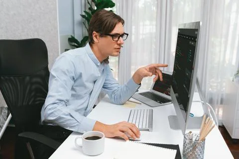IT developer pointing on coding software on pc comparing laptop. Pecuniary. 写真素材