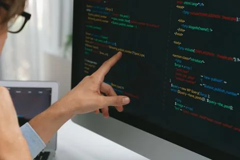 IT developer pointing on coding software on pc comparing laptop. Pecuniary. Foto stock