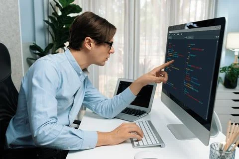 IT developer pointing on coding software on pc comparing laptop. Pecuniary. 스톡 사진