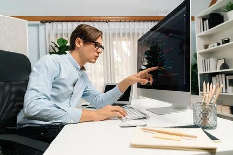 IT developer pointing on coding software on pc comparing laptop. Pecuniary. 스톡 사진