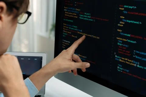 IT developer pointing on coding software on pc comparing laptop. Pecuniary. Foto stock
