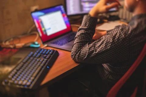 IT developer programmer working and coding on his worplace at home, laptop an 库存照片